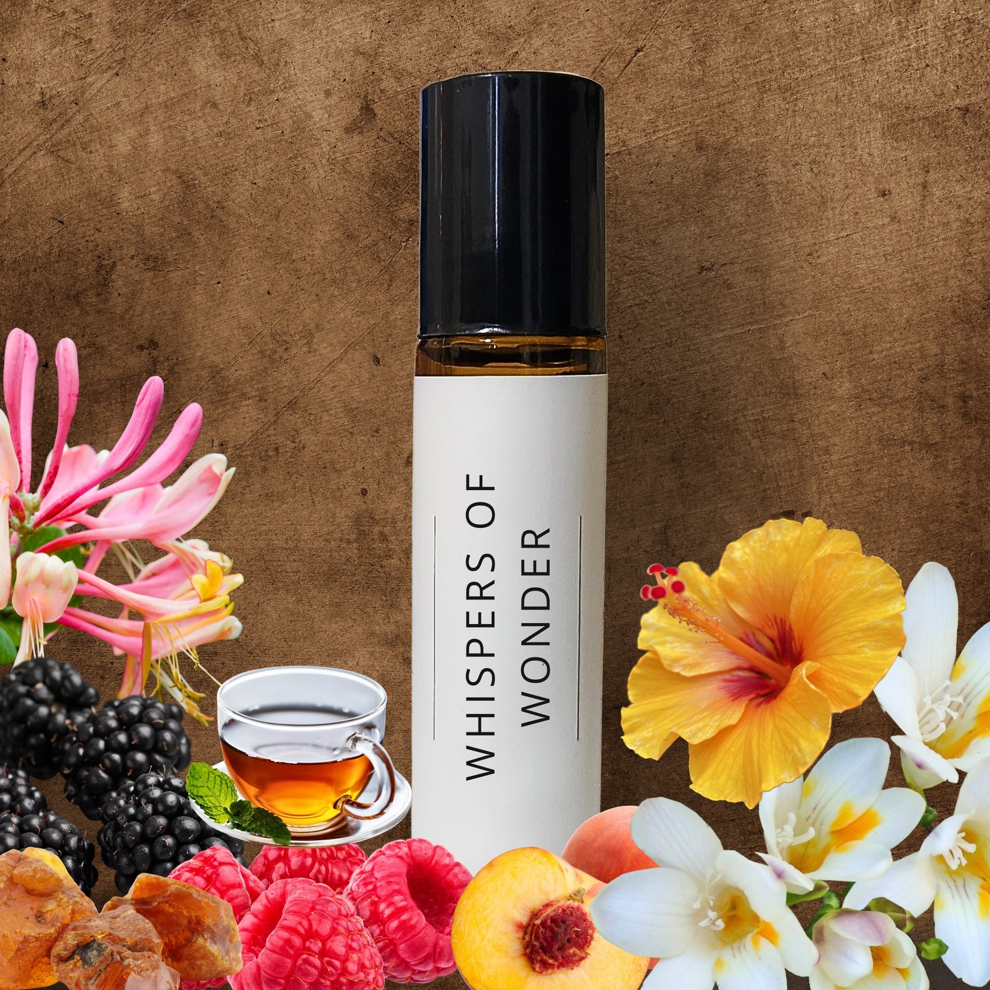 10ml Roller bottle perfume oil labelled 'Whispers of Wonder' surrounded by flowers, berries, and a teacup on a textured brown background.